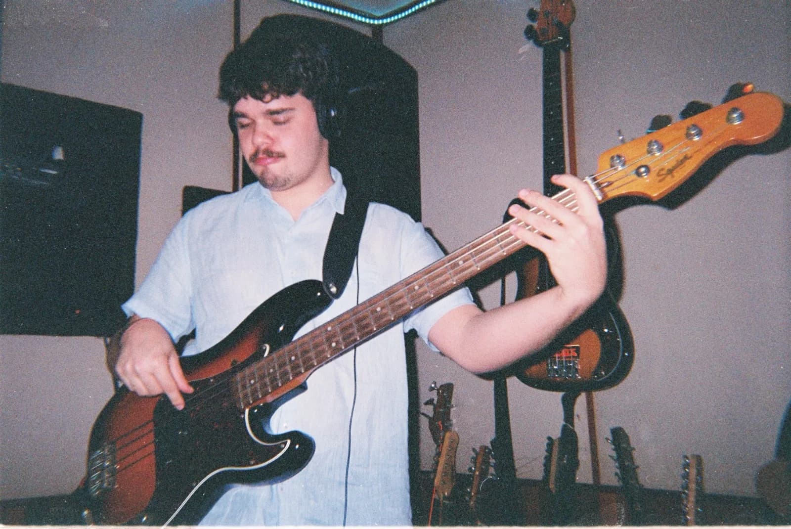Baixo entre guitarras na parede
